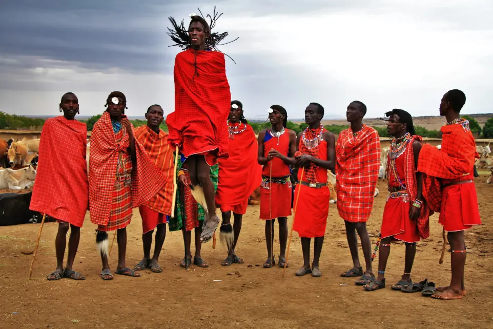 Masai Mara cultural tours group of Masai men wearing red suits standing on brown soil